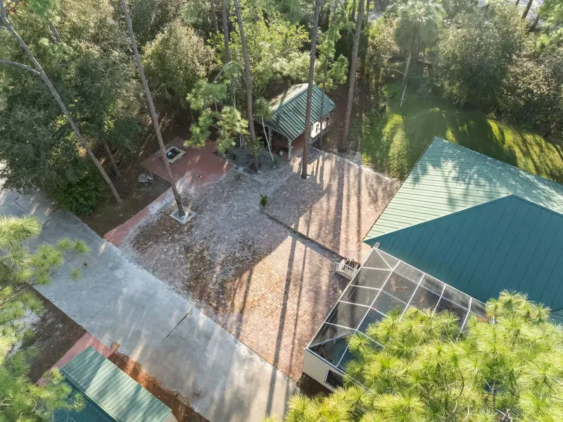 Backyard surrounded by trees and cobblestones